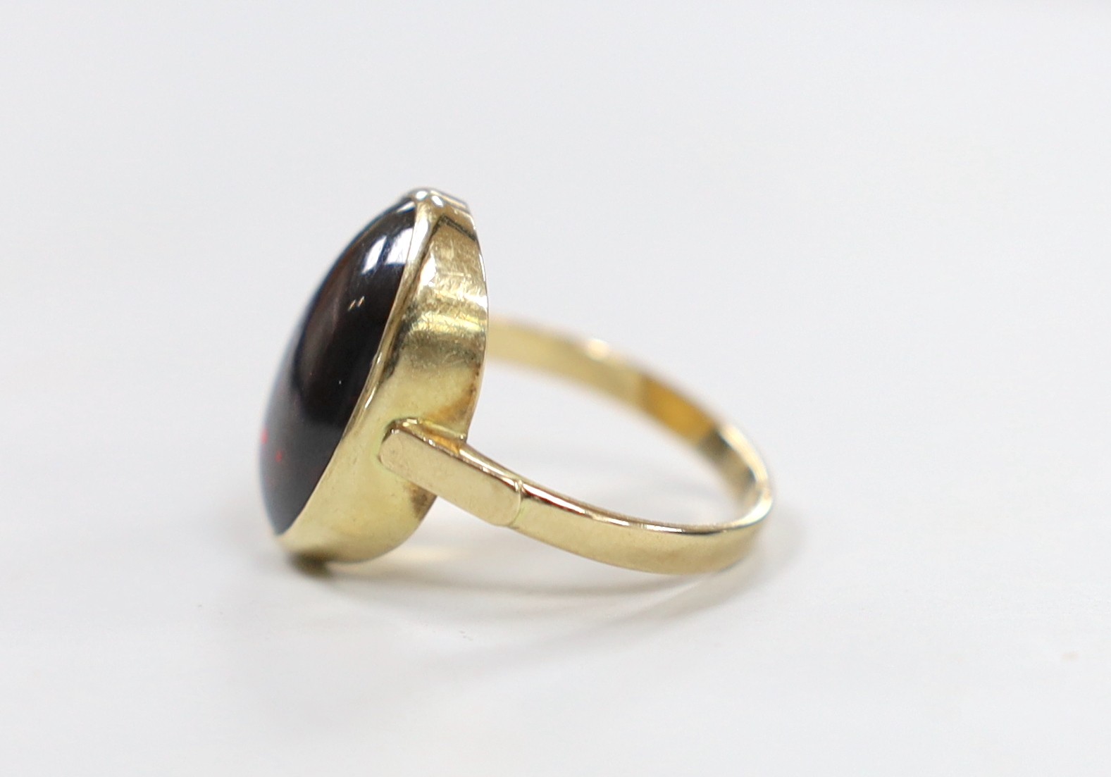A 9ct and foil backed? oval cabochon garnet set ring, size O, gross weight 5.2 grams.